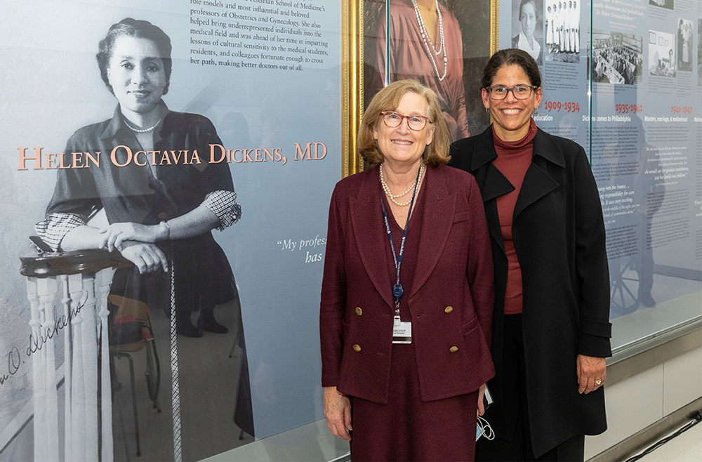 Deborah Driscoll, MD, and Elizabeth Howell, MD, stand beside the display and portrait of Helen O. Dickens, MD.